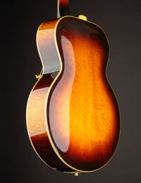 Close-up of a sunburst acoustic guitar on a dark background