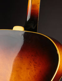 Close-up of a guitar's body and neck on a dark background