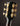 Close-up of a guitar headstock with tuning pegs on a dark background