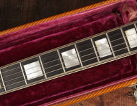 Guitar neck in a red case on a wooden surface