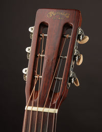 Close-up of a guitar headstock with 'Martin' branding on a dark background
