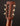 Close-up of a guitar headstock with tuning pegs on a dark background
