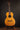 Acoustic guitar on a stand against a dark background