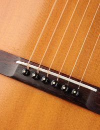 Close-up of a guitar's soundboard with strings and bridge