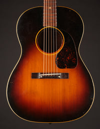 1947 Gibson LG-2 acoustic guitar with a sunburst finish on a dark background