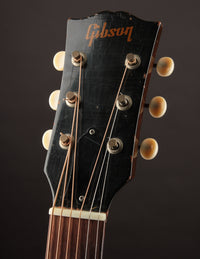 Gibson guitar headstock with tuning pegs on a dark background