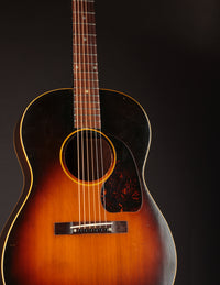 1947 Gibson LG-2 acoustic guitar with a sunburst finish on a dark background
