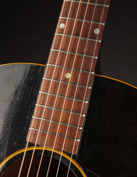 Close-up of a 1947 LG-2 fretboard with a dark background