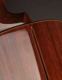 Close-up of a wooden guitar with a focus on the neck and body.