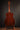 Acoustic guitar on a stand against a dark background