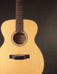 Acoustic guitar with a natural wood finish on a black background