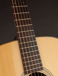 Close-up of a guitar's neck and headstock on a dark background