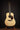 Acoustic guitar on a stand against a black background
