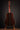 Acoustic guitar on a stand against a black background, back view