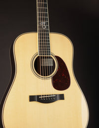 Acoustic guitar with a natural finish on a black background