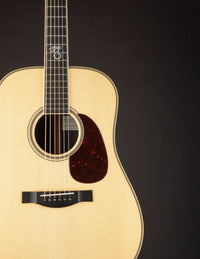 Acoustic guitar with a natural finish on a black background