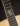Close-up of a guitar's fretboard with a brand logo on a dark background