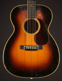 Vintage acoustic guitar with a sunburst finish on a dark background