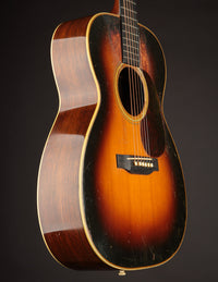 Acoustic guitar with a sunburst finish on a dark background