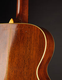 Close-up of a wooden guitar with a dark background