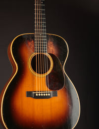 Vintage acoustic guitar with a sunburst finish on a black background