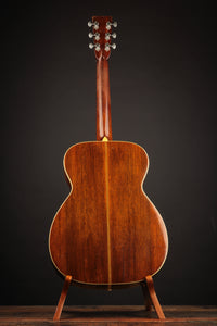 Wooden guitar on a stand against a dark background