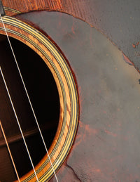 Close-up of an acoustic guitar's soundhole and wooden body