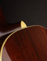 Close-up of a guitar's wooden body on a dark background