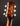 Close-up of a guitar headstock with tuning pegs on a dark background