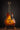 Acoustic guitar on a stand against a dark background