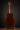 Acoustic guitar on a stand against a dark background