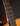 Close-up of a guitar neck with frets and strings against a dark background