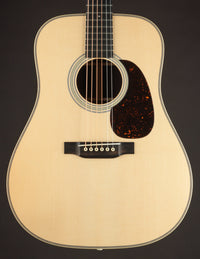 Acoustic guitar with a natural wood finish on a black background