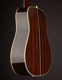 Close-up of a guitar's back with a dark brown finish on a black background
