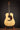 Acoustic guitar on a stand against a dark background