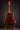 Acoustic guitar on a stand against a dark background