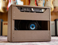 Back view of Fender guitar amplifier with guitars in the background