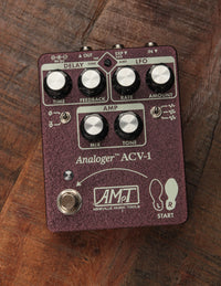 Guitar effects pedal with control knobs on a wooden surface