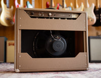 Back view of guitar amplifier with guitars in the background