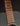 Close-up of a guitar's neck with frets and strings against a dark background