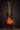 Acoustic guitar on a stand against a dark background