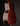 Close-up of a guitar's back with a dark brown finish on a black background
