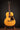 Acoustic guitar on a stand against a dark background