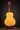Acoustic guitar on a stand with a dark background