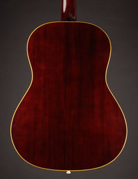 Back view of a dark red acoustic guitar on a black background