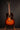 Acoustic guitar on a stand against a dark background