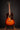 Acoustic guitar on a stand against a dark background