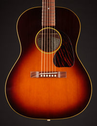 Acoustic guitar with a sunburst finish on a black background