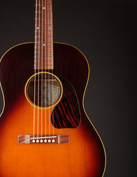 Acoustic guitar with a sunburst finish on a black background