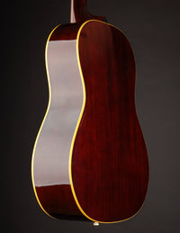 Acoustic guitar with a sunburst finish on a black background, back view